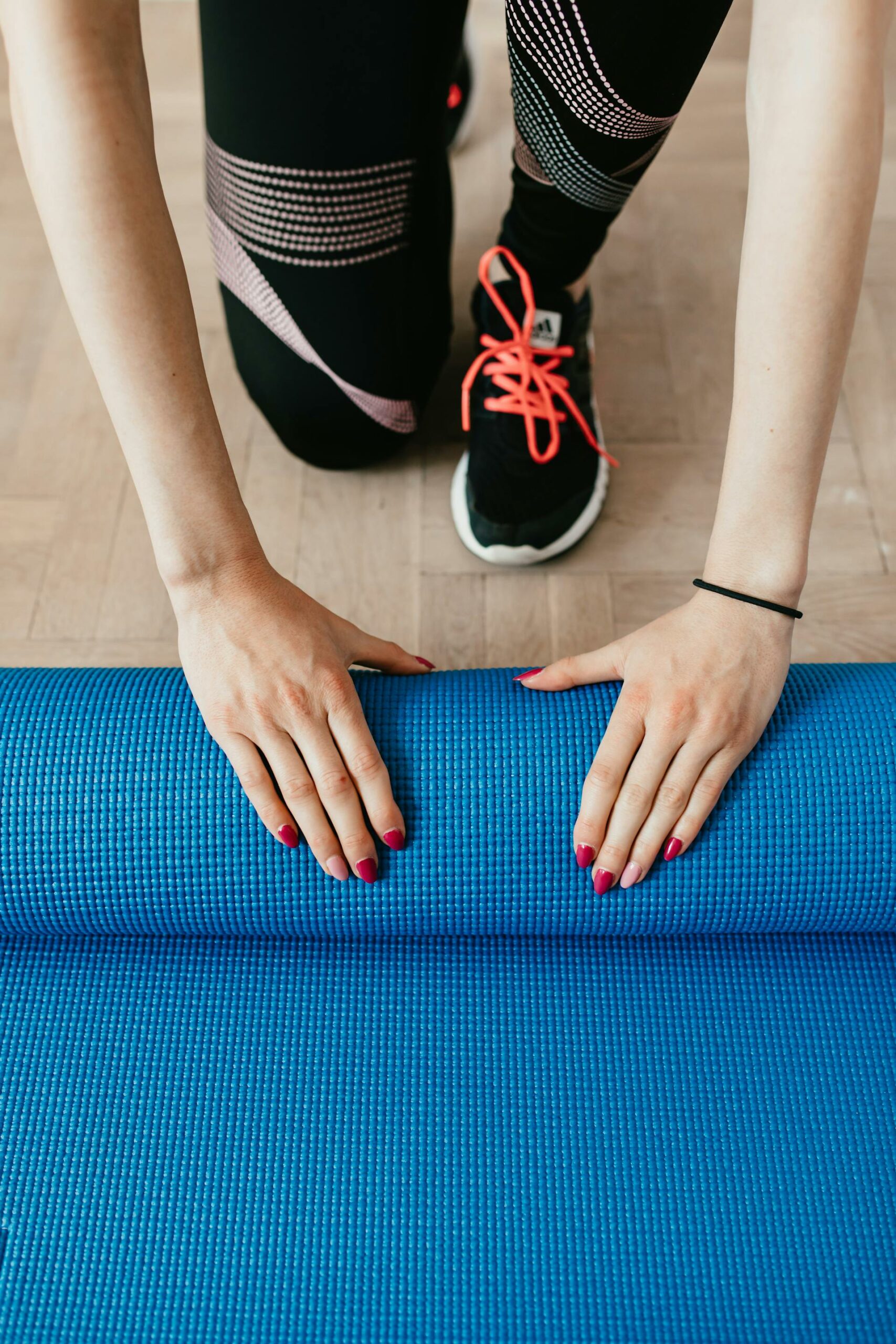 A person rolling up a blue mat.